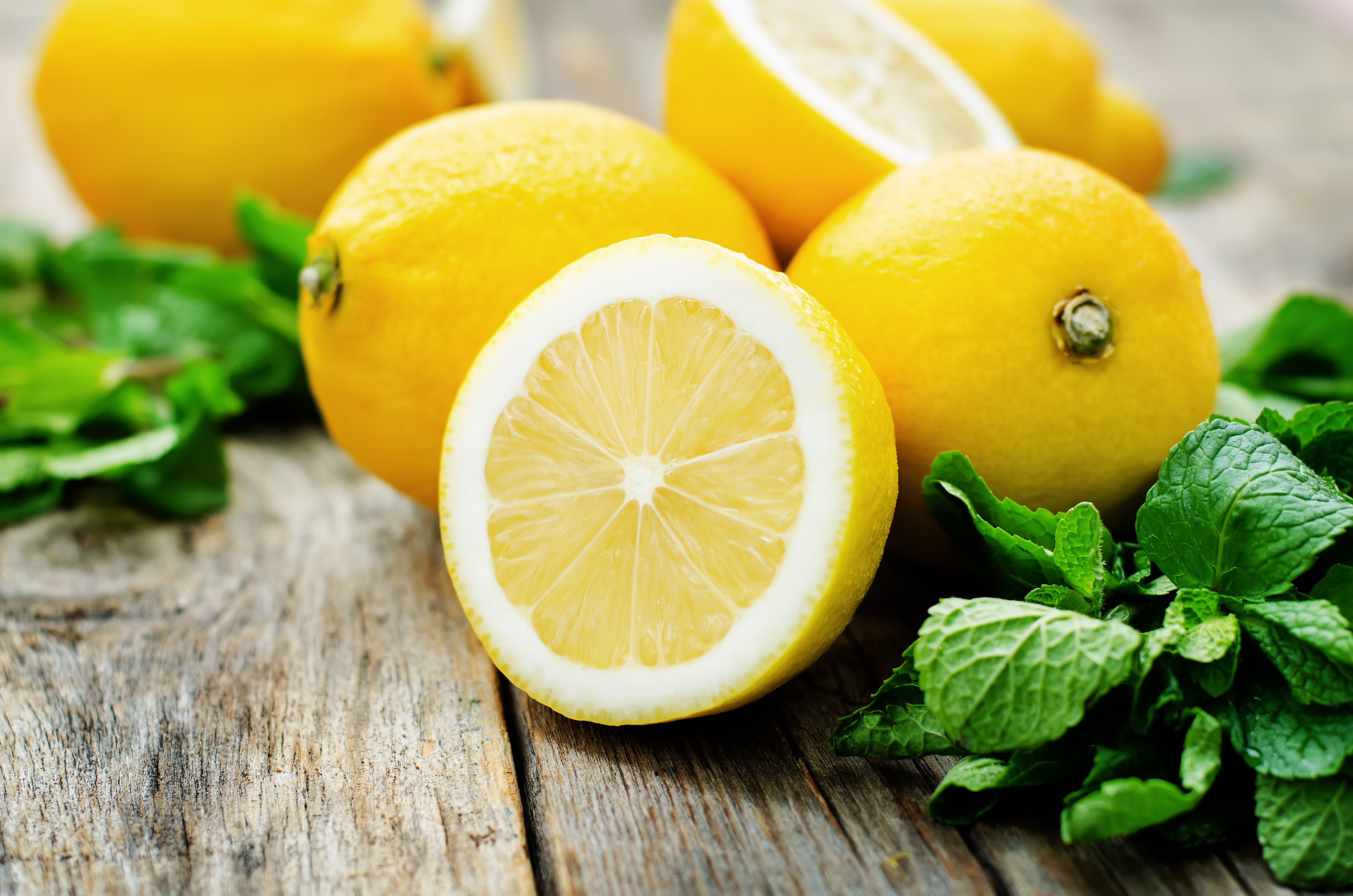 lemons and mint on a dark wood background. tinting. selective focus