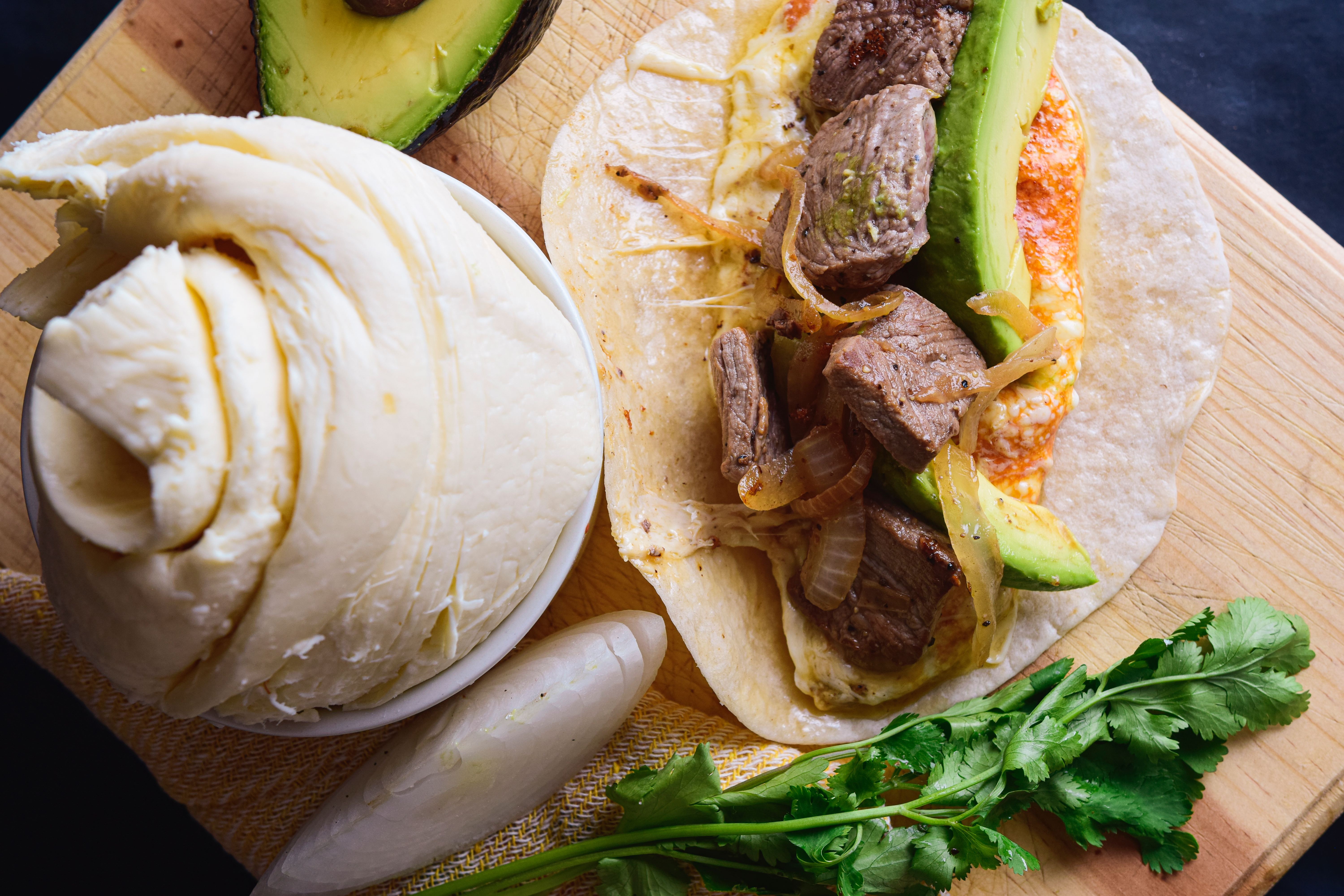 Traditional Oaxaca cheese, with some other elements from mexican food, a quesadilla made with flour tortilla, cheese, meat, onion and spicy sauce, avocato and coriander.