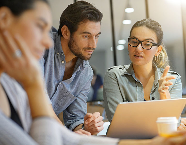 Regulatory professionals looking over a laptop